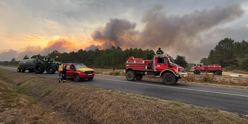 Convoi de pompiers et d'agriculteurs le long d'une forêt en feu en Gironde.