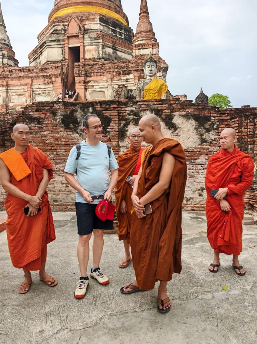 Jean-Noël Sanchez en échange avec des moines bouddhistes devant un temple historique en Thaïlande