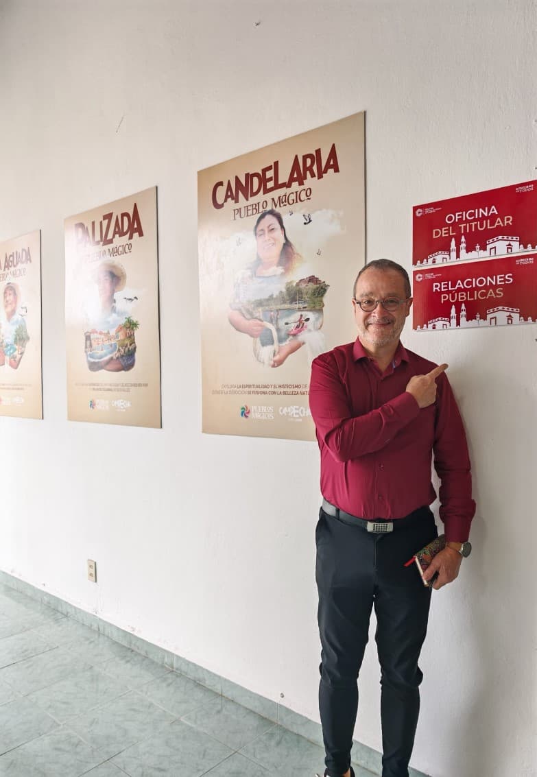 Jean-Noël Sanchez dans un couloir d’offices ; panneaux et affiches promotionnelles (Campeche, Mexique)