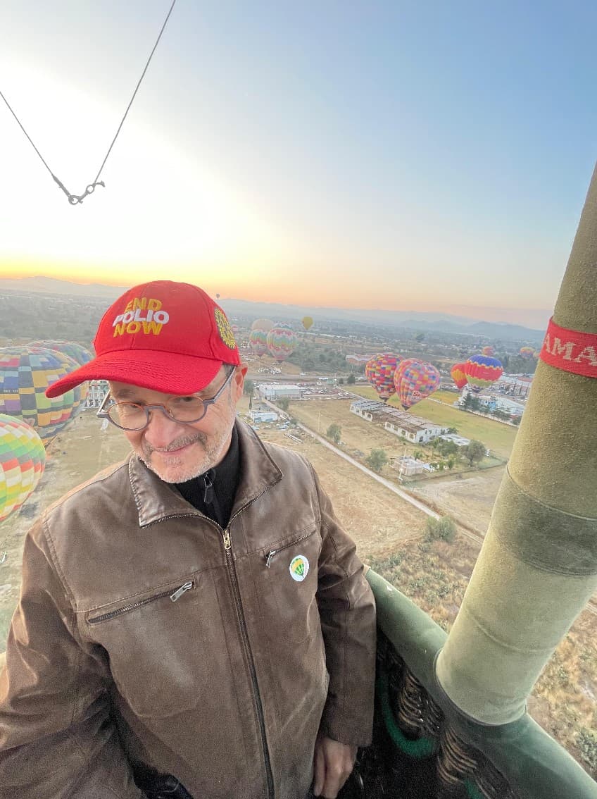 Jean-Noël Sanchez dans la nacelle d’une montgolfière au lever du jour, ciel rempli de ballons